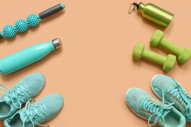 Bej arka planda spor ayakkabıları ve farklı spor ekipmanlarından yapılmış çerçeve