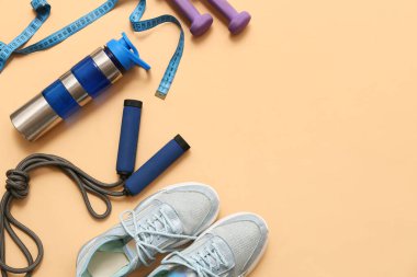 Bej arka planda spor ayakkabıları, mezuralar ve spor aletleri