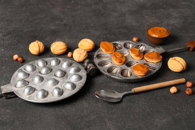 Lezzetli ceviz şekilli kurabiyeler haşlanmış süt ve siyah grunge masasında pişirme formu.