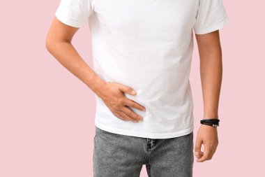 Young man with appendicitis on pink background, closeup clipart