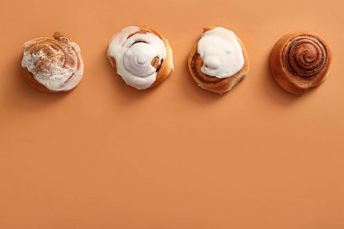 Kahverengi arkaplanlı tatlı tarçınlı rulo.