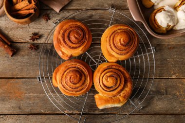 Tahta arka planda tatlı tarçınlı rulolarla dur