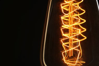 Siyah arkaplanda parlayan klasik ampul, yakın plan