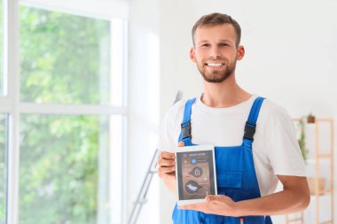 Odada alarm sistemi yüklü tablet bilgisayar tutan erkek işçi