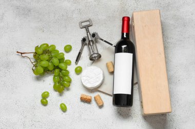 Bir şişe şarap, aperatifler ve grunge grisi arka planda tirbuşon.