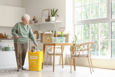 Mutfakta çöp toplayan son sınıf öğrencisi kadın.