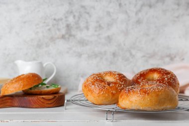 Beyaz ahşap masada lezzetli simitlerle ayakta durun.