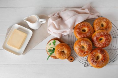 Beyaz ahşap arka planda lezzetli simitlerle ayakta durun.