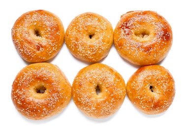 Beyaz arka planda susam tohumlu lezzetli simitler.