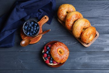 Mavi ahşap arka planda böğürtlenli lezzetli simit tabağı.