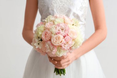 Beyaz arka planda güzel bir düğün buketi olan gelin