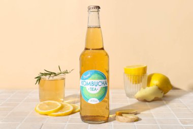 Limonlu ve zencefilli, bej fayanslı bir şişe ve bir bardak lezzetli kombu çayı.