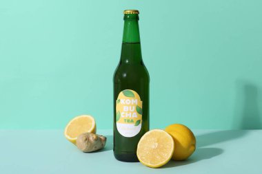 Limonlu bir şişe lezzetli kombu çayı ve turkuaz arka planda zencefil.