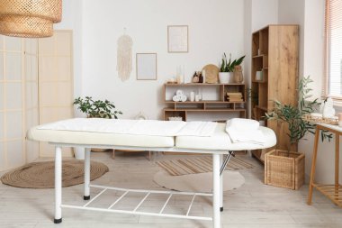 Kanepesi, masası ve raf ünitesi olan bir kaplıca salonu.