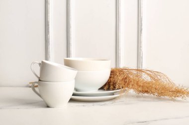 Aydınlık masada çay takımı ve kuru sazlıklar