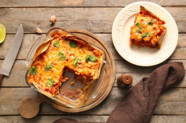 Lezzetli enchilada ve ahşap arka planda baharatlar ile kompozisyon