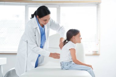 Klinikte küçük bir hastayla çalışan kadın osteopat.