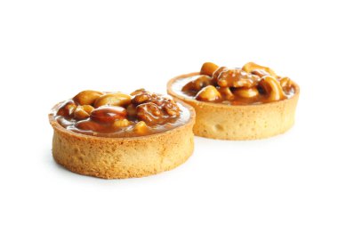 Beyaz arka planda karamelli ve fındıklı lezzetli tartlar.