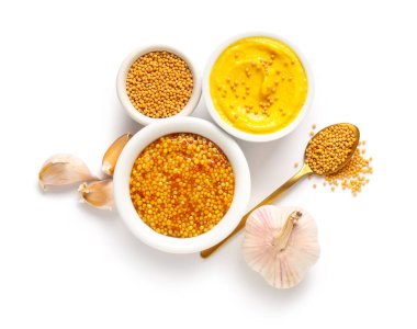 Beyaz arka planda tohumlu ve sarımsaklı bir kâse Dijon hardalı.