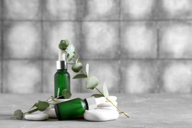 Spa taşları ve okaliptüs şişeleri grunge arka planda gerekli yağ