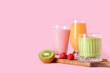 Pembe arka planda çilekli taze meyve püresi ve kivi.