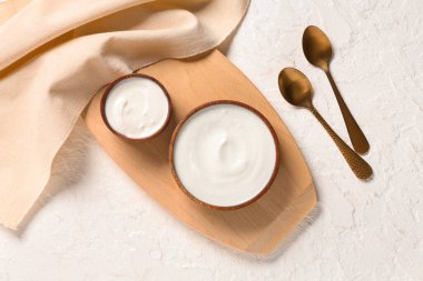 Beyaz arka planda ahşap kaseler dolusu lezzetli yoğurt