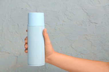 Renk duvarına sprey boya konan kadın eli, yakın plan.