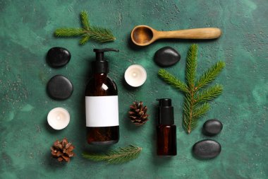 Renkli arka planda kozmetik ürünleri, spa aksesuarları ve köknar dallarıyla kompozisyon
