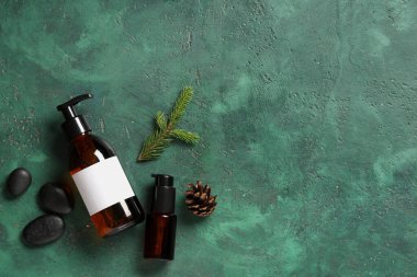 Renkli arka planda kozmetik ürünleri, spa taşları ve köknar dalıyla kompozisyon