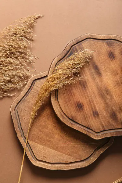 stock image Composition with wooden cutting boards and dry reeds on color background, closeup