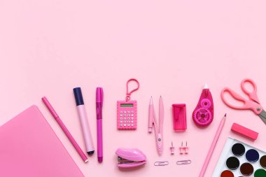 Pembe arkaplanda parlak kırtasiye malzemesi olan kompozisyon