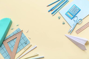 Renk arkaplan üzerinde kağıt uçak ile farklı kırtasiye seti