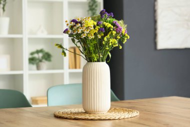 Yemek masasının üzerinde kır çiçekleri olan vazo, yakın plan.