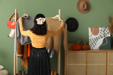 Giyim kuşamında kıyafet seçen güzel genç bir kadın.