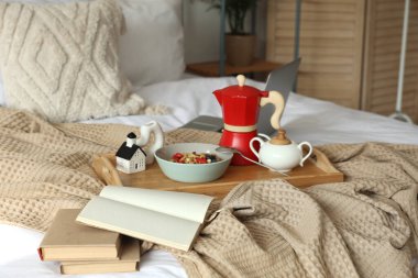 Kahvaltı tepsisi, kitap ve dizüstü bilgisayar odada.