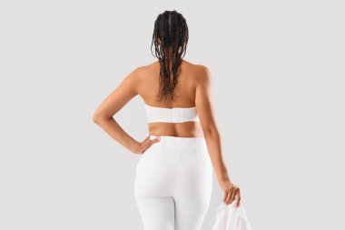 Hafif arka planda rastalı, şık genç bir kadın.