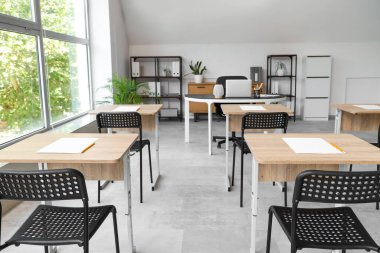 Modern boş sınıflarda kağıtlı ve sandalyeli masalar