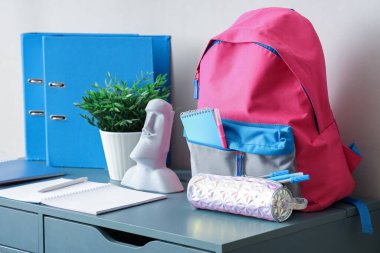 Beyaz duvarın yanındaki okul çantalı şık çocuk işyeri.