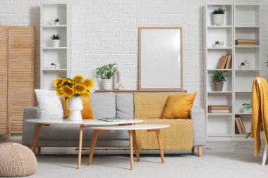 Süslü oturma odasındaki kahve masasında ayçiçekli vazo.