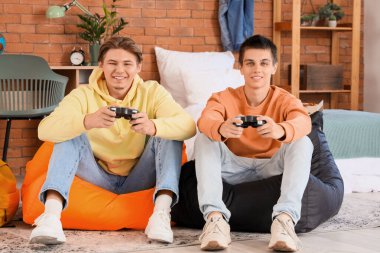 Yurt odasında video oyunu oynayan erkek öğrenciler