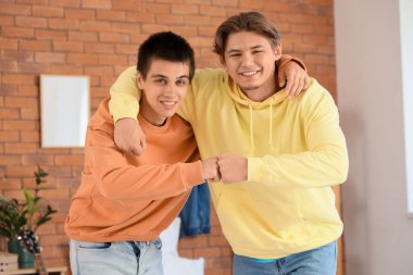 Erkek öğrenciler yurt odasında yumruk tokuşturuyor.