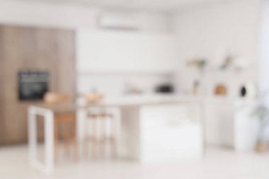 Beyaz tezgahlı ve masalı aydınlık mutfağın bulanık görüntüsü