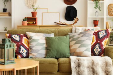 Oturma odasında şık yastıkları olan yeşil kanepe.