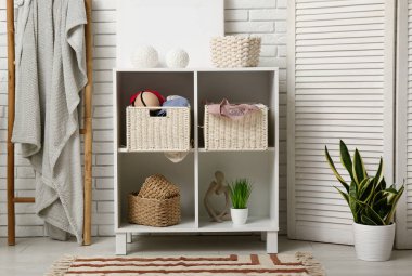 Çekmeceleri, merdiveni ve katlanmış ekranı olan odanın içi.