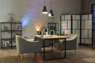 Podcaster 'ın iş yeri, raf üniteleri ve parlayan lambaları olan karanlık stüdyonun içi.