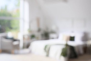 Yeşil bitkiler ve koltuk ile aydınlık yatak odasının bulanık görüntüsü