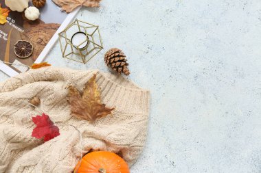 Sıcak süveter, dergi ve açık arkaplanda güzel bir sonbahar dekoru olan kompozisyon