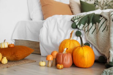 Işıklı yatak odasında kabaklar yerde.