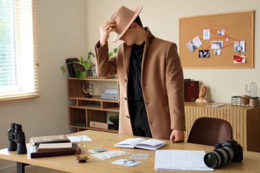 Masanın yanındaki erkek dedektif.