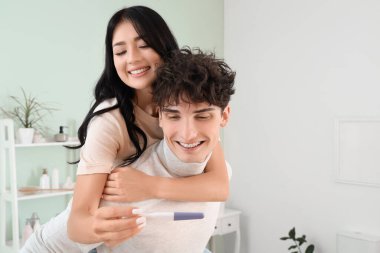 Banyoda hamilelik testi olan mutlu genç bir çift.